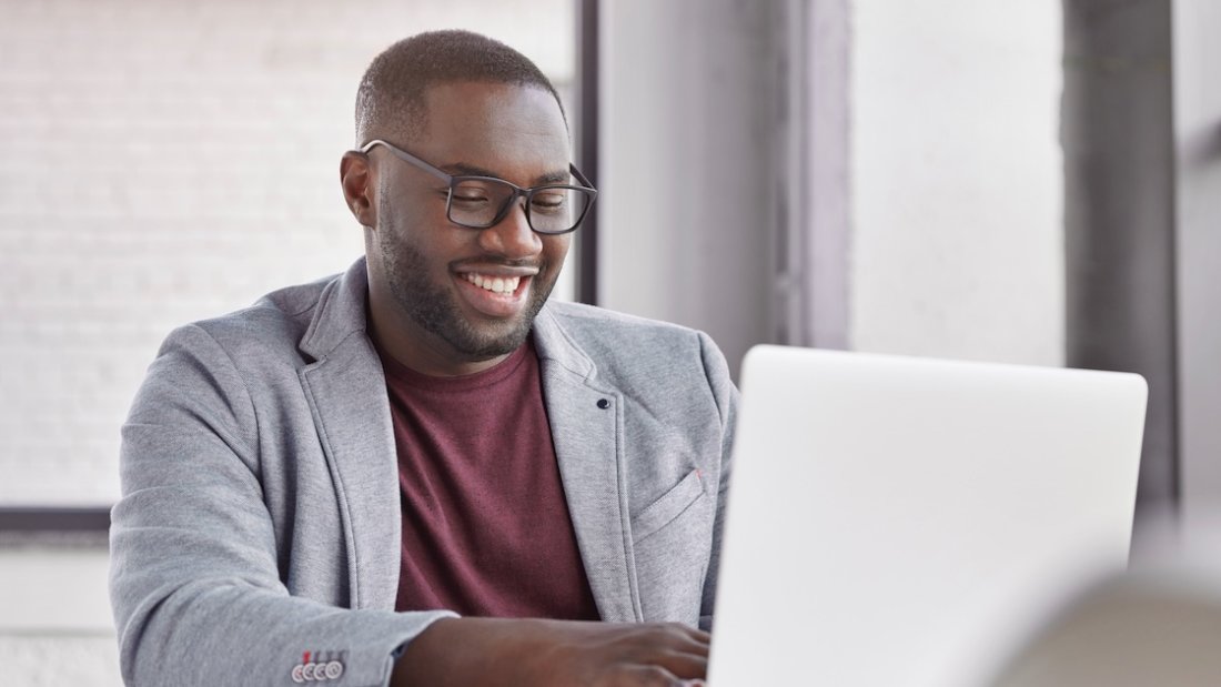 Mann sitzt mit Brille vor Laptop und ordnet seine Sammlungen